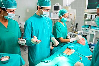 Surgeons standing next to a patient in an operating theatre-stock-photo