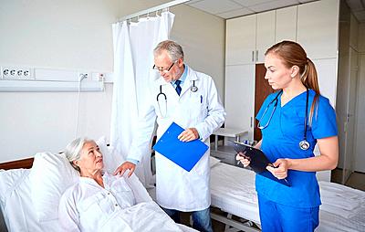 medicine, age, health care and people concept - doctor and nurse with clipboards visiting senior patient woman at hospital ward-stock-photo